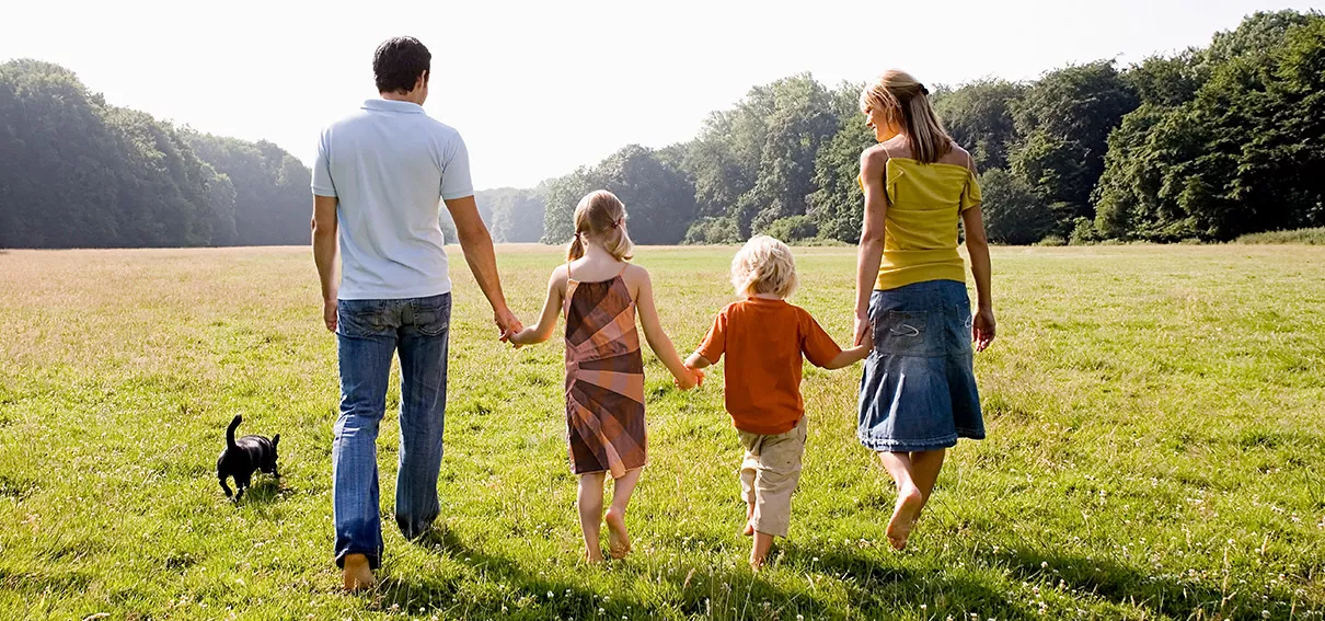 Family walking together holding hands.